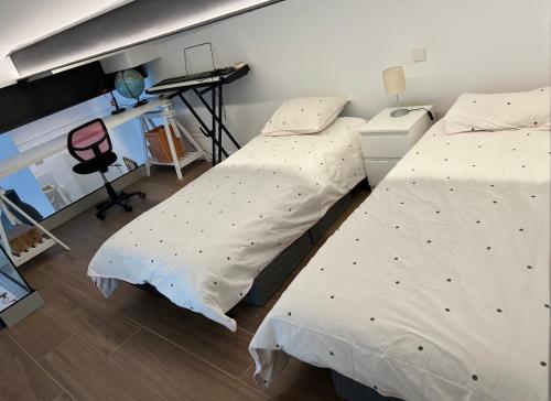 two twin beds in a room with a desk at Remanso de luz y silencio en plena Puerta del Sol in Madrid