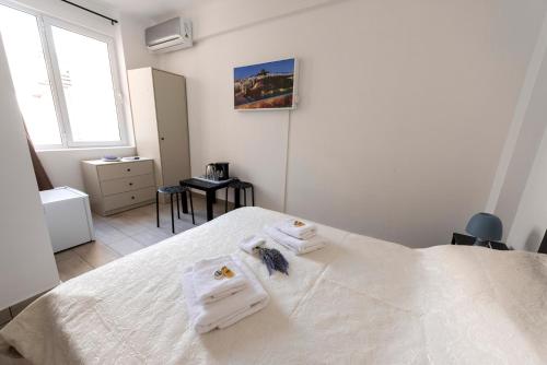 a bedroom with a white bed with towels on it at ATHENS COMMERCIAL in Athens