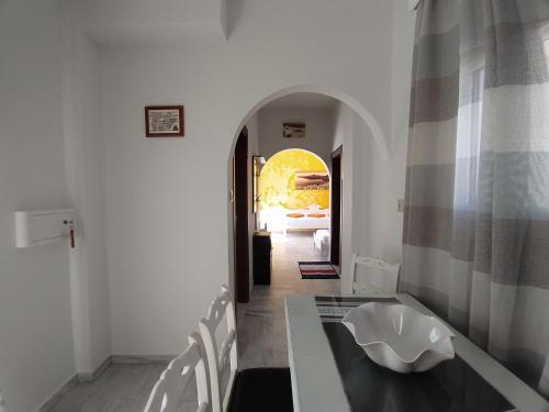 una sala da pranzo con tavolo, sedie e corridoio di Chariot Apartments Santorini a Kamari