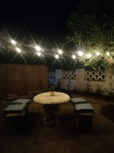a table in a courtyard at night with lights at Villa Rebecca in Nardò