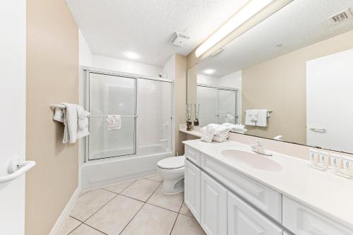 a white bathroom with a toilet and a sink at Beach Colony E10B in Pensacola