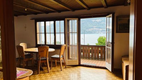 a dining room with a table and a view of the water at Casa do Lago in Leissigen