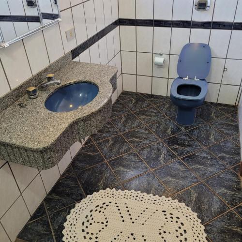 a bathroom with a blue toilet and a sink at Hostel da Spipe in Campo Grande