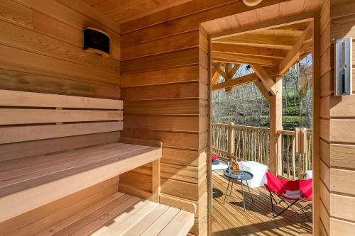 a wooden sauna with a table and a chair at Les Cabanes Suspendues in Satillieu