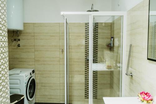 y baño con ducha y lavadora. en Apartman Stil en Bugojno