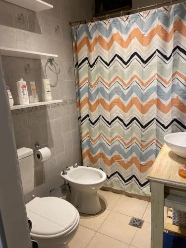 a bathroom with a toilet and a shower curtain at Padre Vázquez Apartment in Maipú