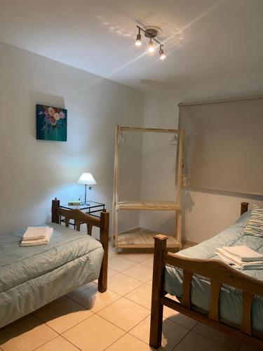 Habitación con 2 camas, mesa y espejo. en Padre Vázquez Apartment en Maipú