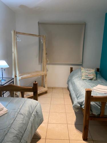 Habitación con 2 camas, mesa y estante en Padre Vázquez Apartment en Maipú