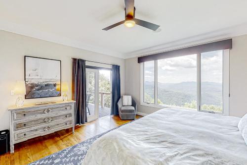 a bedroom with a bed and a large window at Jump Off Rock Retreat in Hendersonville