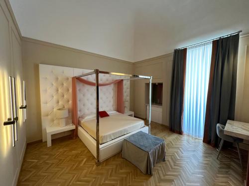 a bedroom with a four poster bed and a desk at Palazzo Bonomi in Bisceglie