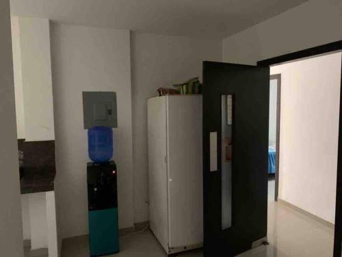 Zimmer mit einem Kühlschrank und einem TV an der Wand in der Unterkunft Casa grande familiar Crucita in Crucita