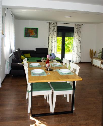 a dining room table and chairs in a living room at Kraljeva hiža - Apartmani i sobe Kralj in Sveti Martin na Muri