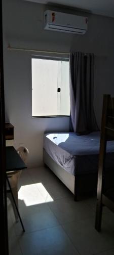 a small bedroom with a bed and a window at Casa com piscina e espaço gourmet a 30m da praia! in Alcobaça