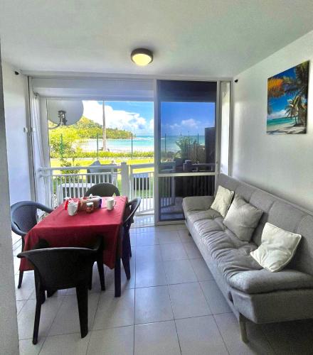 ein Wohnzimmer mit Couch und Tisch in der Unterkunft STUDIO VUE MER VILLAGE VIVA BAS DU FORT, Gosier in Le Gosier