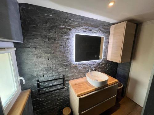 ein Badezimmer mit einem Waschbecken und einer Ziegelwand in der Unterkunft Appartement 3 pièces in Briançon