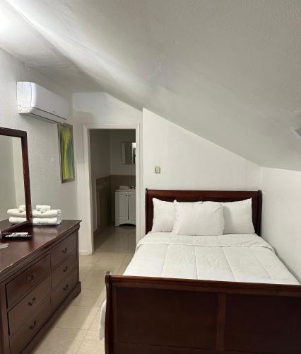 Un dormitorio con una cama grande con una cómoda y un espejo. en Sun Fun Hotel, en Nassau