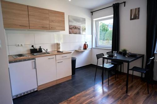 a kitchen with white cabinets and a table and a window at Mivano-Apartments *Netflix *Zentral *WIFI in Celle