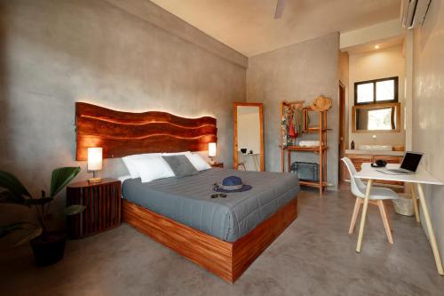 een slaapkamer met een bed en een bureau met een laptop bij Che Puerto Escondido Hostel & Bar Adults Only in Puerto Escondido