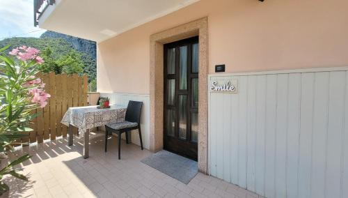 un patio con una mesa y una puerta con un cartel que diga sonrisa en Maison AnnaBelle, en Ceniga
