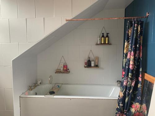 La salle de bains est pourvue d'une baignoire et d'un rideau de douche. dans l'établissement Trendy Westbourne Flat, à Bournemouth