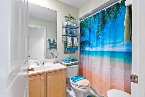 a bathroom with a sink and a toilet and a shower curtain at Carols Palm in Port Saint Lucie