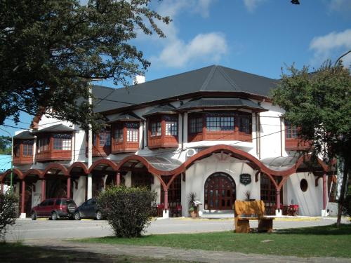 un grand bâtiment blanc avec un toit noir dans l'établissement Grand Hotel - Sierra De La Ventana, à Sierra de la Ventana