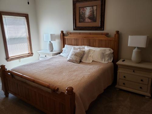 a bedroom with a large bed with two night stands and a window at Alpine Escape in Somerset