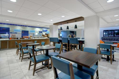 a restaurant with tables and chairs and a counter at Holiday Inn Express Marietta - Atlanta Northwest, an IHG Hotel in Marietta