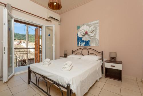 1 dormitorio con 1 cama y balcón en Fay Apartment, en Ágios Stéfanos