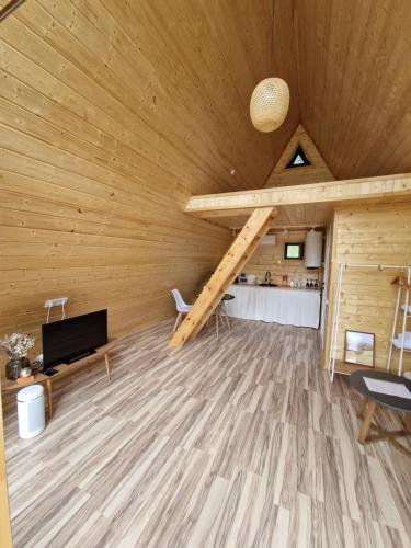 un soggiorno con soffitto in legno e scala di Eywa House a Kamenskoye Plato