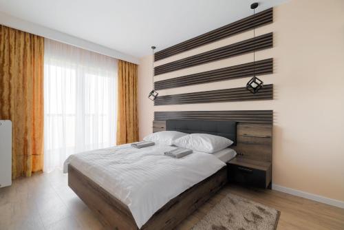 a bedroom with a large bed with a wooden headboard at City View Tower in Poznań