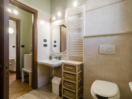 a bathroom with a toilet and a sink and a mirror at Villa Albina in La Loggia
