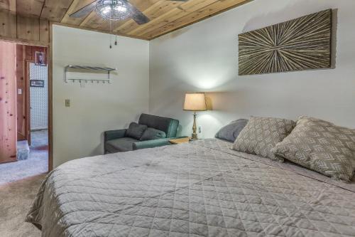 1 dormitorio con 1 cama grande y 1 silla en Cozy Bears Hideaway about 3 Mi From Shaver Lake!, en Shaver Lake