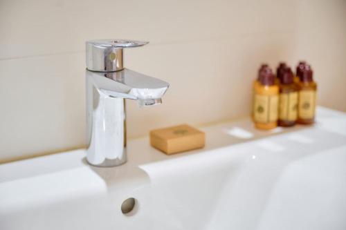 - un lavabo avec robinet et quelques bouteilles dans l'établissement AzurAppart 3-rooms Cannes Carnot, à Cannes