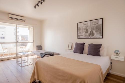 Un dormitorio blanco con una cama grande y una ventana en Espacioso y Luminoso Depto en Belgrano -Roosevelt- en Buenos Aires