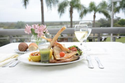 a plate of food on a table with a glass of wine at Sol Victoria Hotel SPA & Casino in Victoria