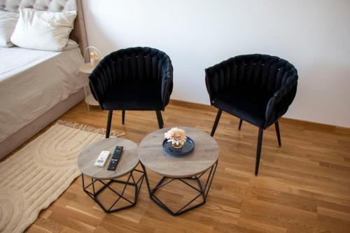 Dos sillas negras y una mesa en una habitación en Harmony Studio Apartment, en Jagodina
