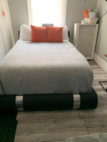 ein Schlafzimmer mit einem großen Bett mit orangefarbenen Kissen in der Unterkunft Cassandra’s Private Room Getaway Heart of Brooklyn in Brooklyn