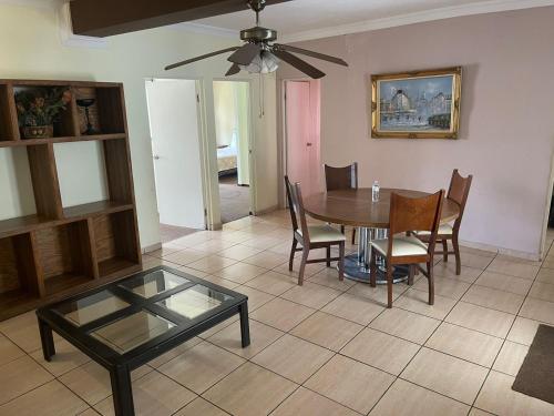 a dining room with a table and chairs and a ceiling fan at Hotel Rincon Real Suites in Durango