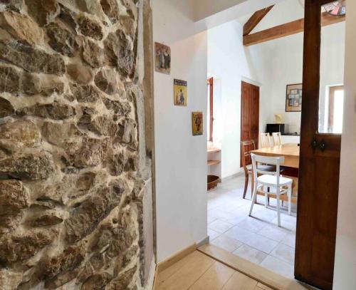 une cuisine et une salle à manger avec un mur en pierre dans l'établissement Les Hauts du Château, à Chambéry