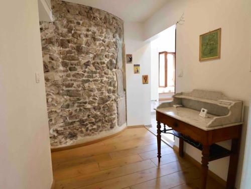 Habitación con piano y pared de piedra. en Superbe appartement T5 - Les Hauts du Château, en Chambéry