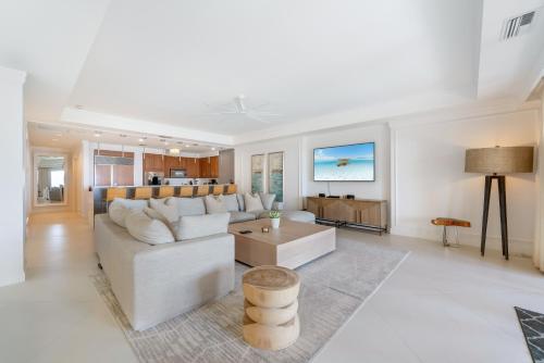 a living room with a white couch and a table at Beach Front Residence 108 located at The Ritz-Carlton in Upper Land