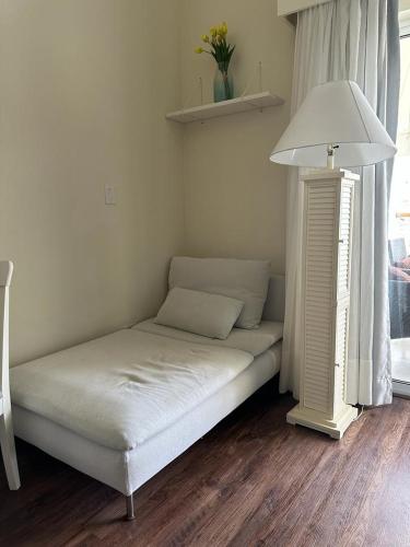 a bed in the corner of a room with a lamp at Hotel Palmera Bayahibe in Bayahibe