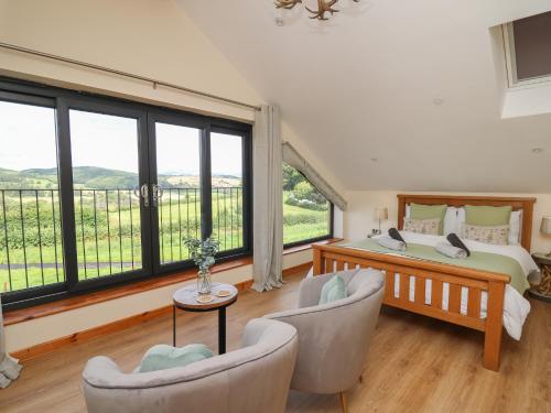 a bedroom with a bed and a large window at Harp Meadow in Presteigne