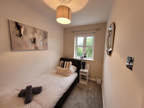 a small bedroom with a bed and a window at Stay @ Enville Close, Birmingham Airport & NEC in Marston Green