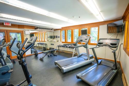 a gym with several tread machines in a room at Whistler Village Inn & Suites in Whistler