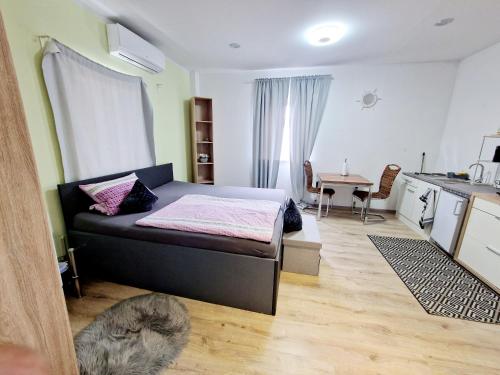 ein kleines Schlafzimmer mit einem Bett und einer Küche in der Unterkunft iBO-APART 1 Zimmer Apartment in Herzogenaurach in Herzogenaurach