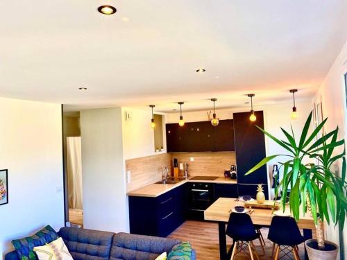 a kitchen and a living room with a blue couch at *Superbe appartement moderne* in Lourdes