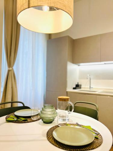 una mesa blanca con platos y vasos. en Tarra Luxury Suite en Milán