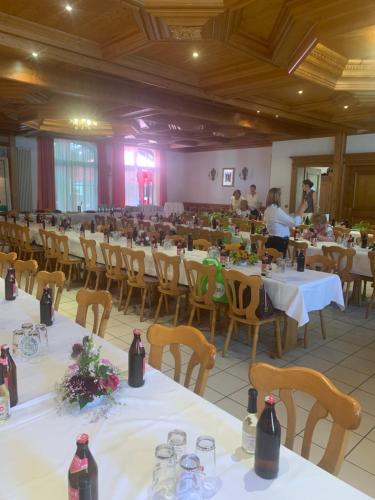 um grande salão de banquetes com mesas, cadeiras e pessoas em Brauerei Gasthof Kraus em Hirschaid